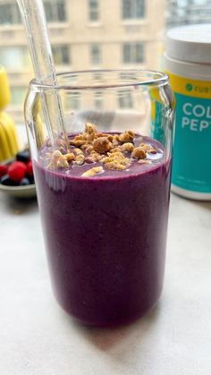 a purple smoothie in a glass with a straw