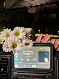 a car dashboard with flowers in the center and an entertainment system on it's dash board