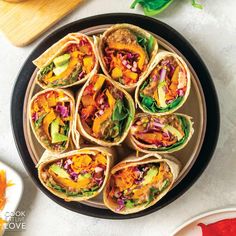 a wooden bowl filled with veggie wraps next to chopsticks