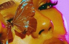 a woman holding a butterfly on her face