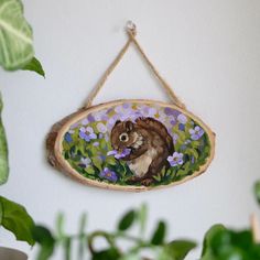 a wooden sign hanging on the side of a wall next to a potted plant