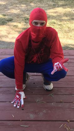 a person in a red hoodie and blue pants crouching down with their hands on the ground