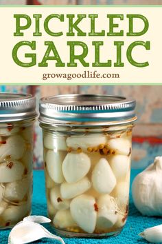 two jars filled with pickled garlic on top of a blue cloth