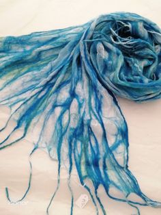 a blue and white scarf laying on top of a table