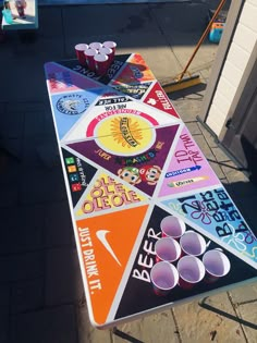 a colorful sign sitting on top of a sidewalk