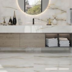 a bathroom with marble counter tops and a round mirror on the wall above it's sink