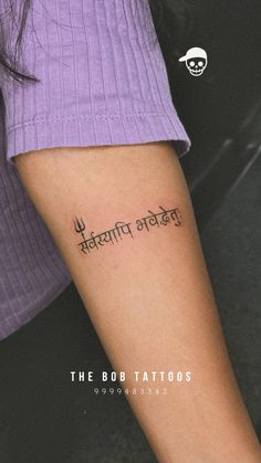 a woman with a tattoo on her arm that says the bob tattoos in two languages