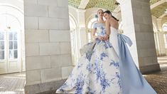 two beautiful women standing next to each other in front of an arched building with arches