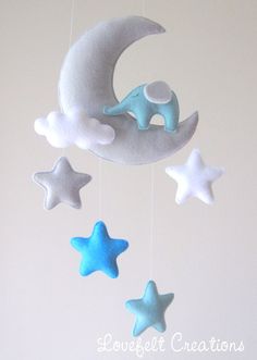 a crib mobile with stars and a crescent hanging from it