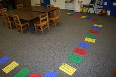 an empty classroom with colorful papers on the floor