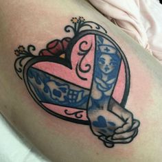 a woman with a tattoo on her stomach holding a heart shaped object in the shape of a cross