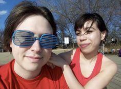 a man and woman wearing sunglasses on the street