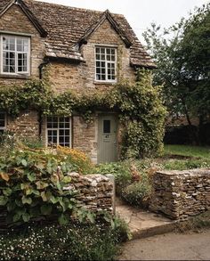 an old stone house with ivy growing all over it