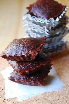 three pieces of brownie sitting on top of each other next to a cupcake tin