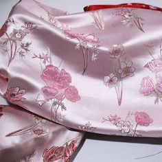 a pink silk scarf with flowers on it