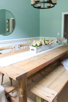 a dining room table and bench in front of a mirror