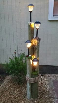 a light pole made out of logs with lights on it and moss growing in the middle