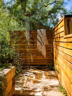 a wooden fence with towels hanging on it's side and trees in the background