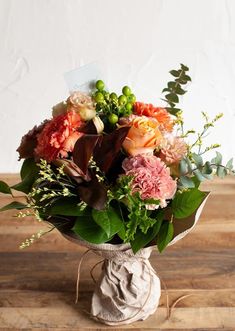 a bouquet of flowers in a vase on a wooden table