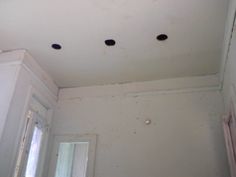 four holes in the ceiling above a window