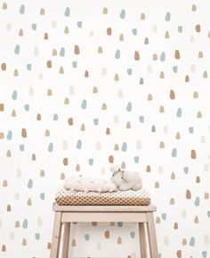 a baby's crib in front of a white wall with multicolored dots