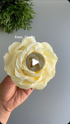 a hand holding a yellow flower with the words easy crafts written on it in white