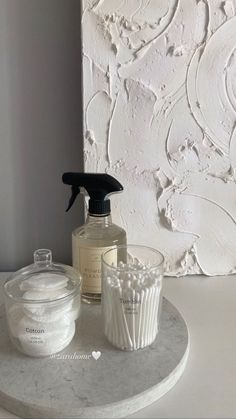 a white table topped with a bottle of liquid and cupcakes