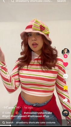 a woman with red hair wearing a pink hat and striped shirt is talking on her cell phone