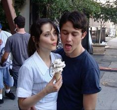 a young man and woman eating an ice cream cone