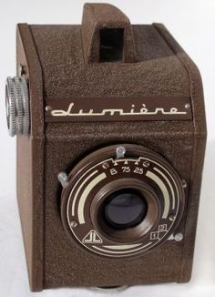 an old brown camera sitting on top of a white table