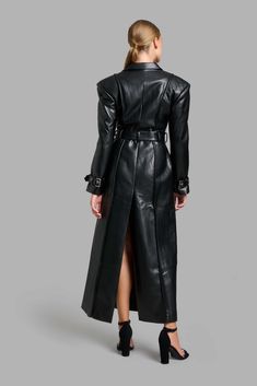 Black faux leather classy trench coat with wide shoulders and shoulder pads. Sleeves are decorated with belts, belt loops, and exserted stitches. Free worldwide shipping! Delivery time: 6-8 days Formal Black Outerwear With Belt Detail, Formal Black Belted Outerwear, Belted Leather Jacket For Office, Office Leather Belted Jacket, Belted Leather Long Coat Jacket For Business, Belted Leather Long Coat For Business, Winter Office Leather Jacket With Belt, Belted Long Leather Jacket For Business, Chic Leather Outerwear With Belt