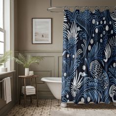 a bathroom with a blue shower curtain next to a bath tub