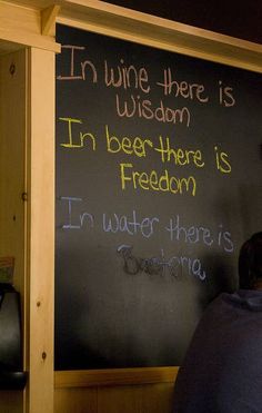 a man writing on a blackboard with chalk