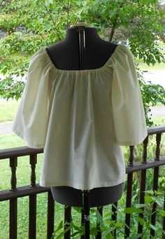 "Made to order This shirt is made from 100% cotton. It has elastic at the neckline and 3/4 length sleeves. Can be worn on or off the shoulder. The 3/4 length sleeve on this shirt makes it cooler for summer festival and faire wear! Available in Bleached White Muslin or Natural Muslin. (Also available different colors of 100% cotton and in a poly cotton blend - message me if you have a color request ). These are all good quality lightweight shirting fabrics. This is a loose fit shirt. Sized to fit Wench Costume, Shirting Fabric, Loose Fit Shirts, Pirate Costume, Peasant Blouse, Women's Costumes, Summer Festival, Halloween Ideas, Bell Sleeve Top