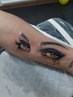 a woman's arm with an eye tattoo on it