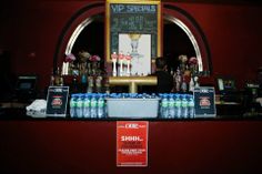 the bar is stocked with bottled water and soft drinks for sale in front of an arched window