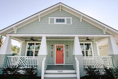 a gray house with white trim and red door