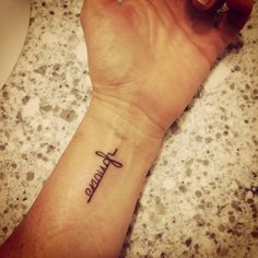 a small wrist tattoo with the word faith on it