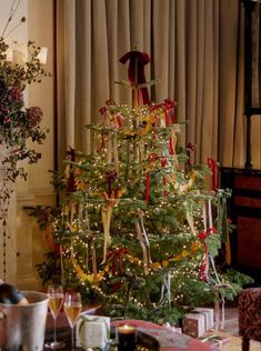 a christmas tree is decorated with ribbons and bows in the living room, along with other holiday decorations