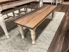 a wooden bench sitting on top of a rug in front of a dining room table