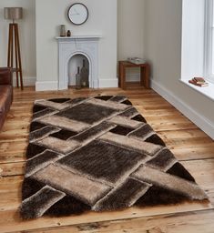 a living room with wood flooring and a large rug on the floor in front of a fireplace