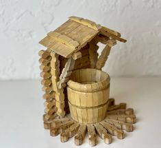 a small wooden house made out of wood logs with a bucket in the foreground