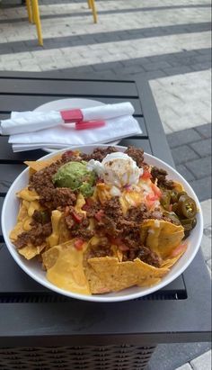 a white plate topped with nachos and cheese