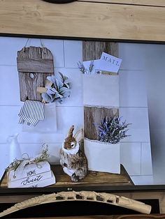 a cat sitting on top of a wooden shelf next to a white bag filled with flowers