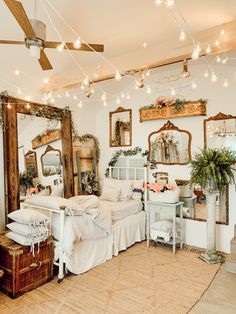 a bedroom with white furniture and lights hanging from the ceiling