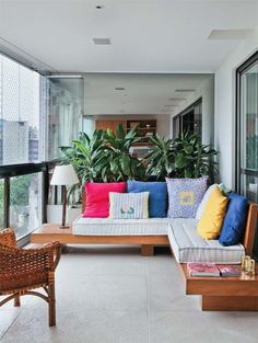 a living room filled with lots of furniture next to a window on top of a white floor