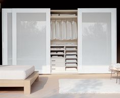 a bedroom with white furniture and open closet doors