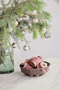 a small bowl filled with donuts next to a christmas tree in a glass jar