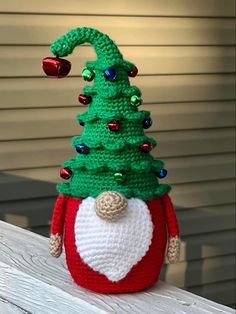 a crocheted christmas tree sitting on top of a wooden table next to a building