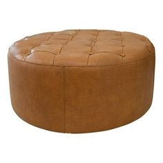 a brown leather ottoman sitting on top of a white floor